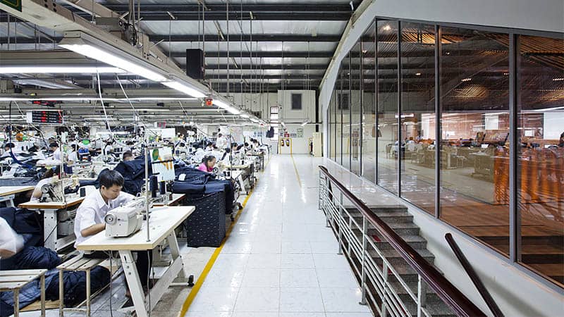 Silkua silk clothing manufacturing factory showcasing advanced production lines with skilled workers sewing custom silk pajamas, custom silk dresses, and custom silk shirts, ensuring high-quality craftsmanship and precision.