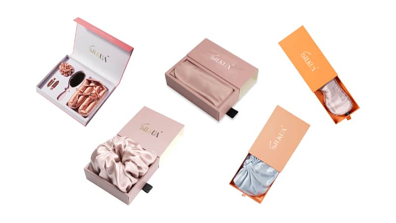 Flat lay of silk accessories including scrunchies, bonnets, eye masks, headbands, and heatless hair curlers used in luxury hotel and spa branding