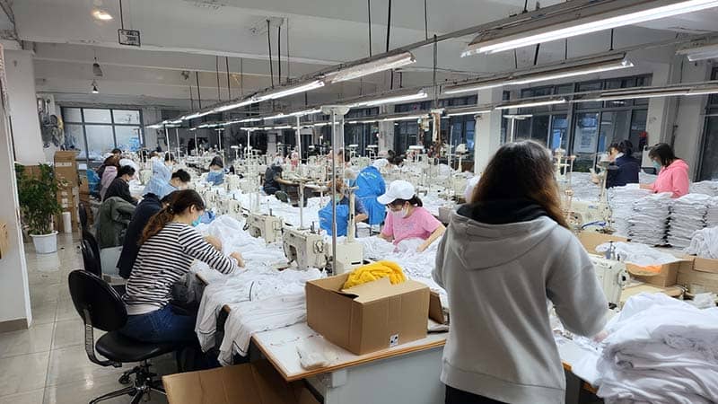 Silk bonnet manufacturer workshop with staff sewing and inspecting silk products, highlighting quality control and professional facilities.