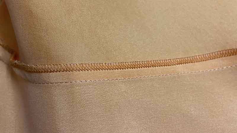Close-up of mulberry silk satin pajamas showing 19–22 momme weave, French seams, and premium sheen for custom silk pajamas