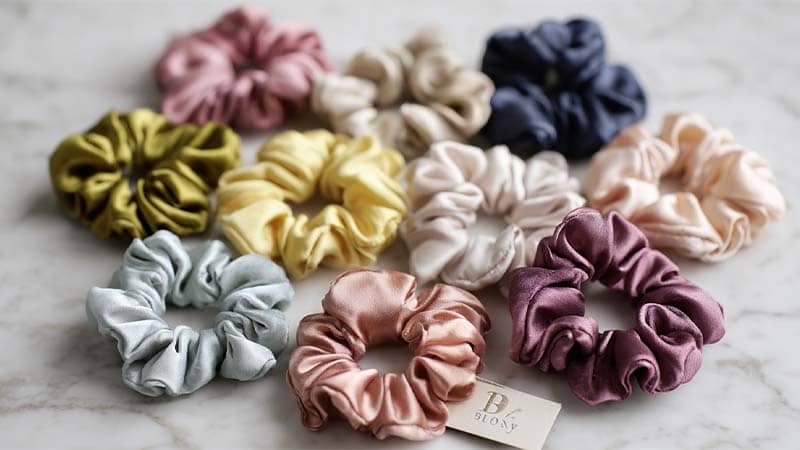 Flat lay of assorted mulberry silk scrunchies in multiple sizes and colors, premium hair accessories for best‑selling silk products on Amazon FBA and Shopify.