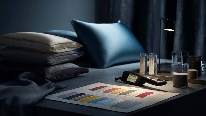 Side‑by‑side silk pillowcases from different dye lots under D65 and TL84 lighting, showing ΔE color tolerance and shade band comparison for silk pillowcase manufacturing